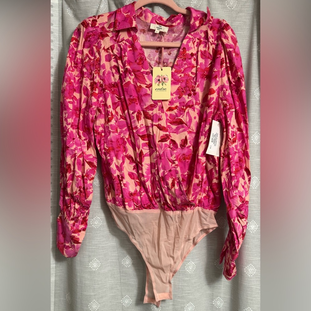 It includes a collared neckline, a v front, long sleeves, a light pink, 2 snap